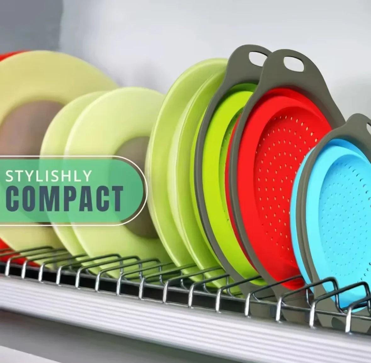 Essential Selects collapsible silicone colanders in red, green, and blue stored compactly in a kitchen dish rack.