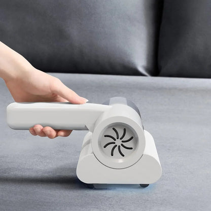 Essential Selects cordless mattress vacuum and mite remover with UV light cleaning a grey fabric sofa surface