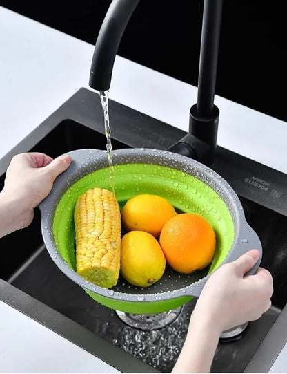 Essential Selects green silicone collapsible colander rinsing corn and oranges in a modern kitchen sink