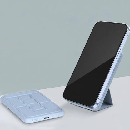 Essential Selects magnetic wireless power bank with foldable stand attached to an iPhone for hands-free viewing