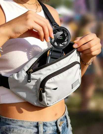 Essential Selects portable handheld turbo fan with LED display being placed into a grey waist bag by a woman