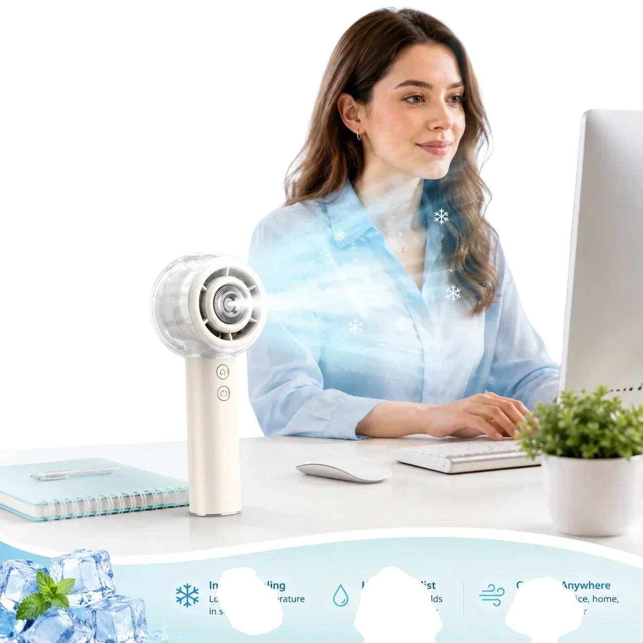 Essential Selects portable misting handheld fan on a desk with a woman working in the background
