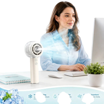 Essential Selects portable misting handheld fan on a desk with a woman working in the background