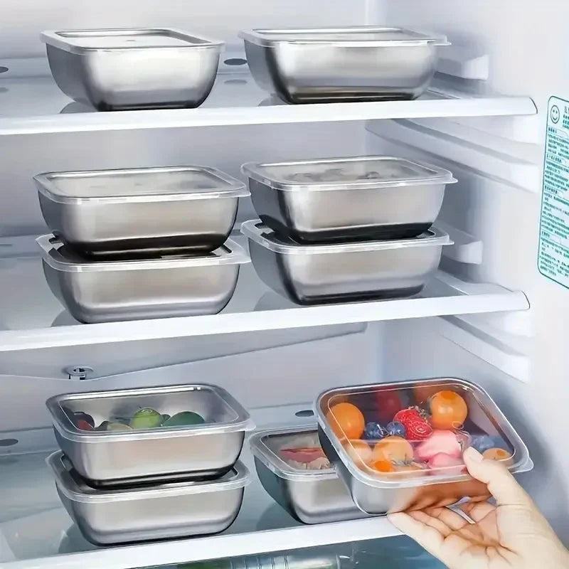 Essential Selects 5-piece stainless steel stackable meal prep containers with clear lids stored in a refrigerator.